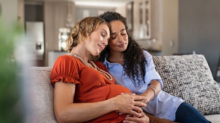 Lovely pregnant lesbian couple at home